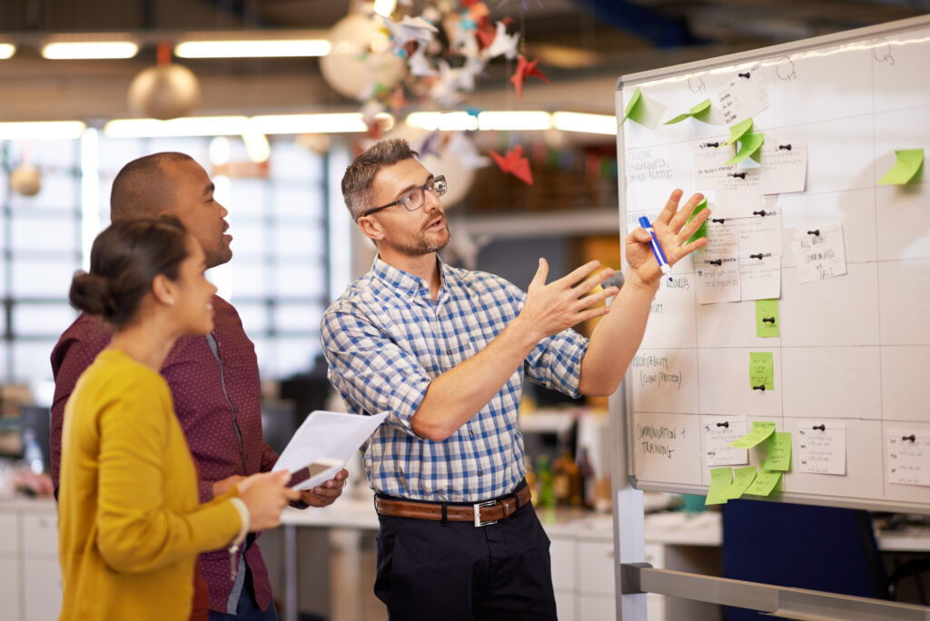 Come up with the idea then execute it. Shot of a group of coworkers brainstorming at a whiteboard.