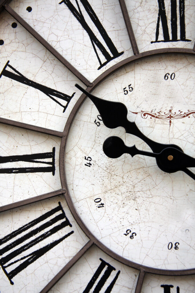 old style black and white clock with roman letters