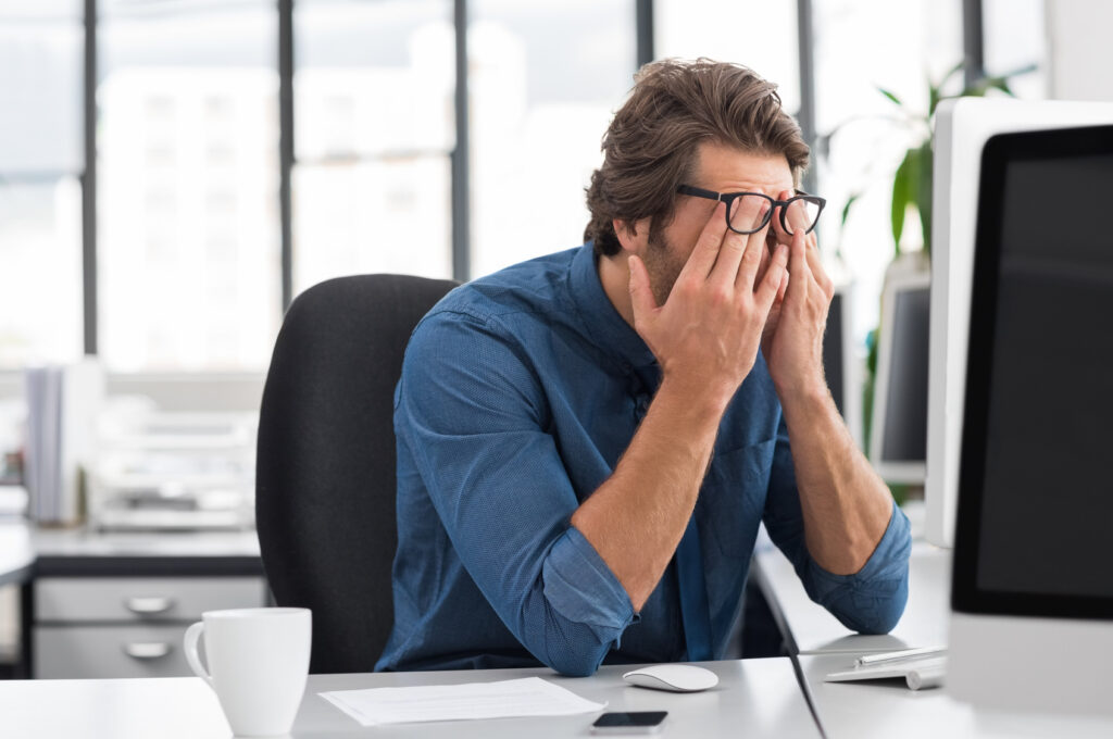 stressed young businessman sitting at his desk