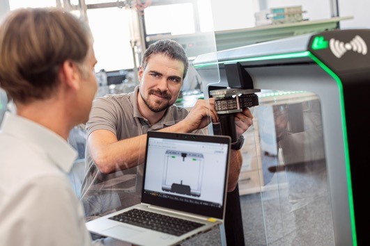 two men working together with a macbook