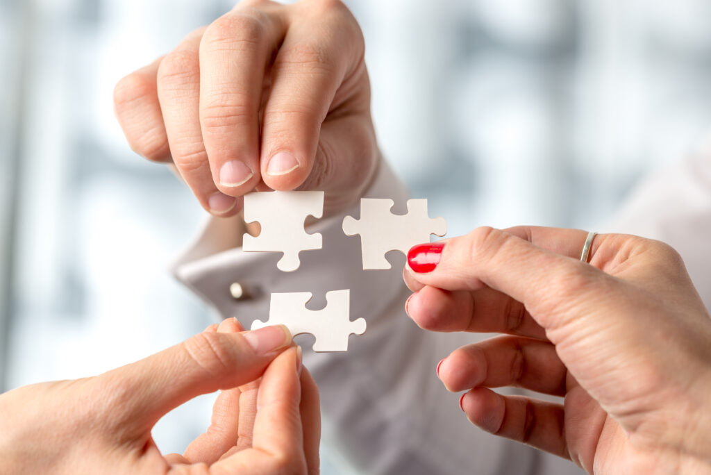 3 Personen fügen Puzzleteile zusammen