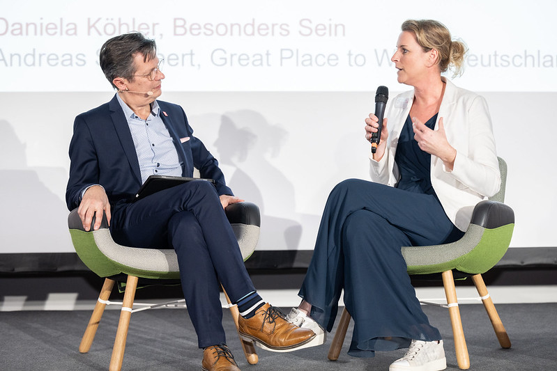 a man and a woman having a live interview on stage