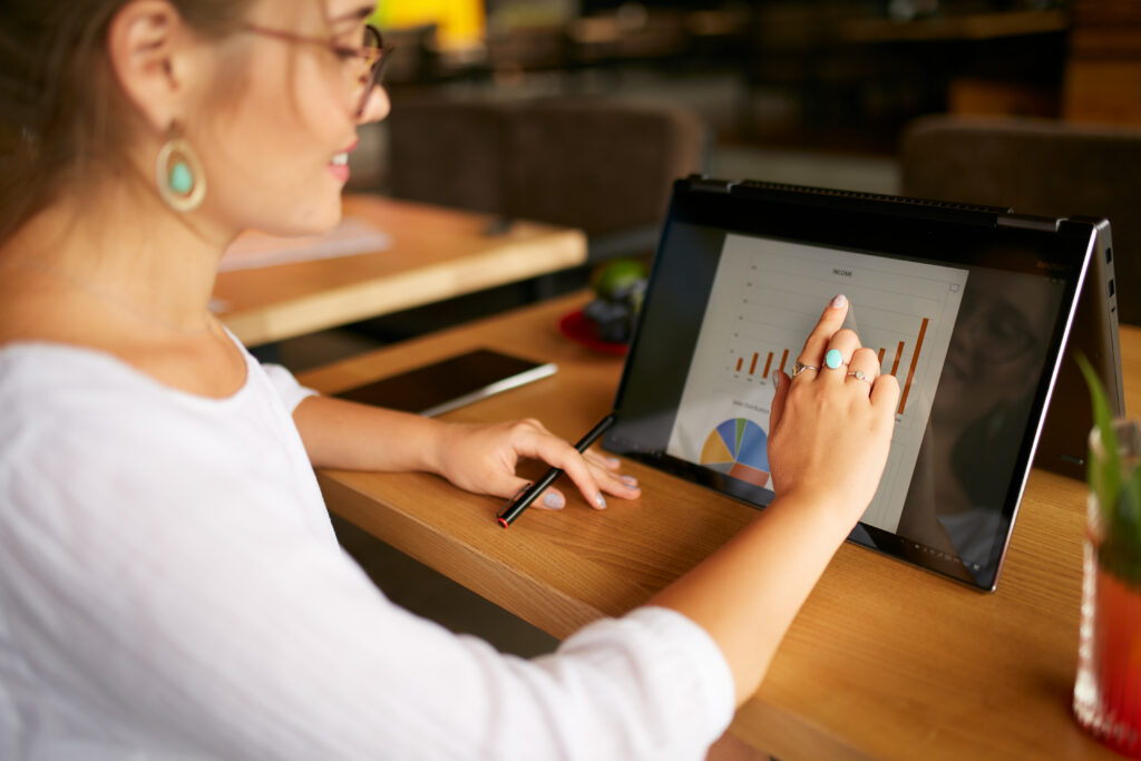 woman with glasses sitting and touching tabletscreen