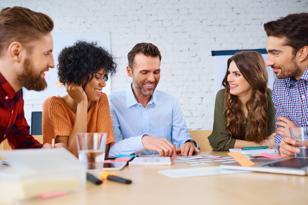 5 Personen sitzen an einem Tisch und denken