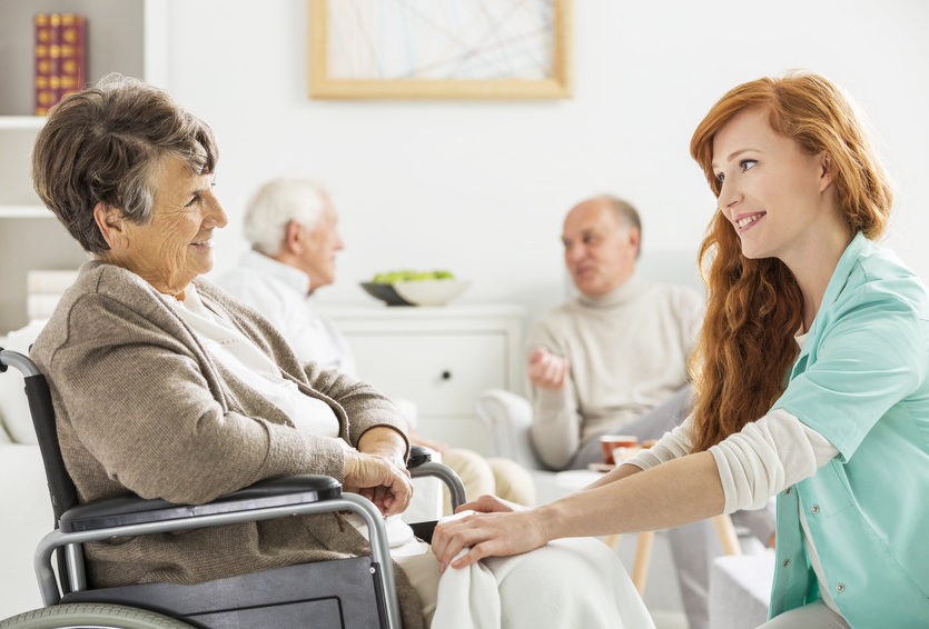 Krankenschwester spricht mit einer älteren Dame