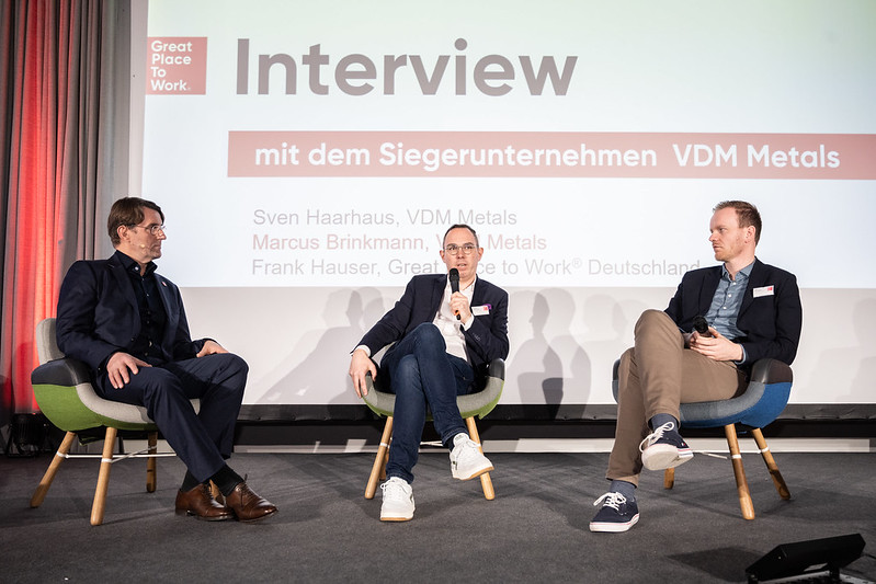 three men sitting together at a presentation