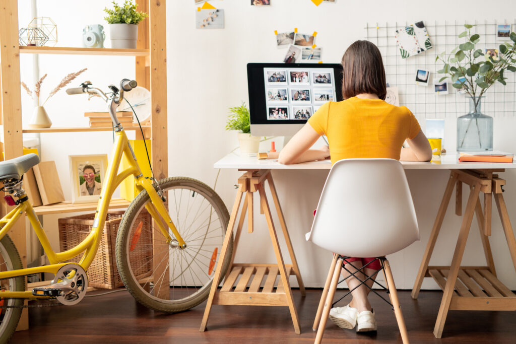 female dressed in yellow working in homeoffice on her laptop