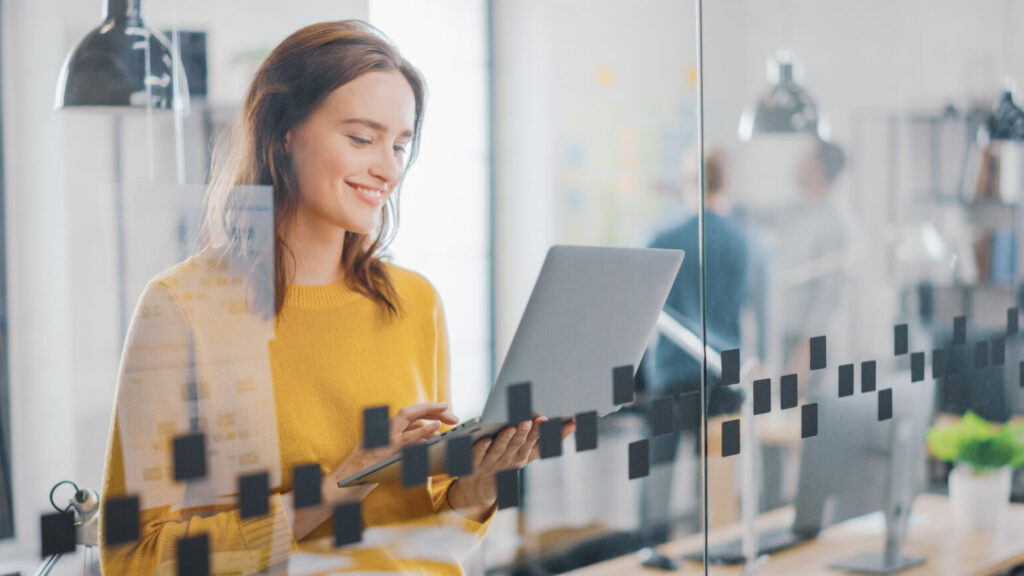 woman smiling and working with a laptop