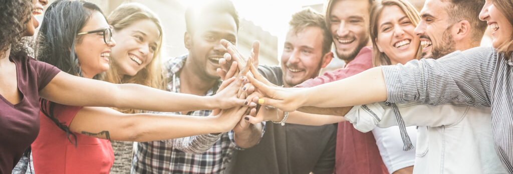 happy coworkers stacking their hands outdoor